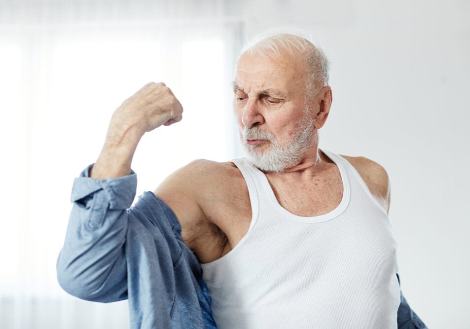 Portrait of a senior man showing biceps and strength
